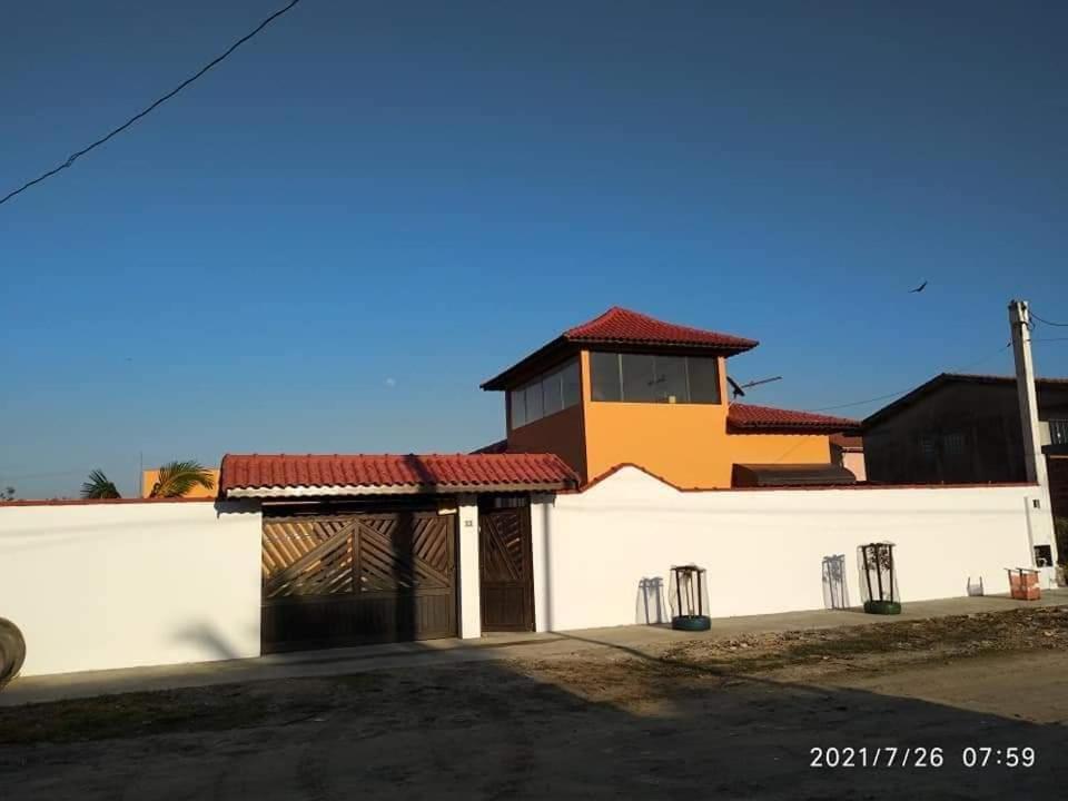 un bâtiment blanc avec un toit rouge dans l'établissement Hospedagem Familiar Yamane, à Ilha Comprida