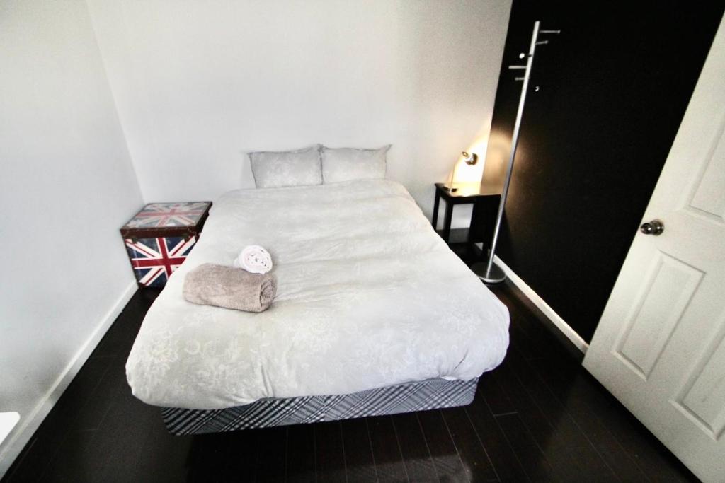 ein Schlafzimmer mit einem großen weißen Bett in einem Zimmer in der Unterkunft The Parkdale Hostellerie in Toronto
