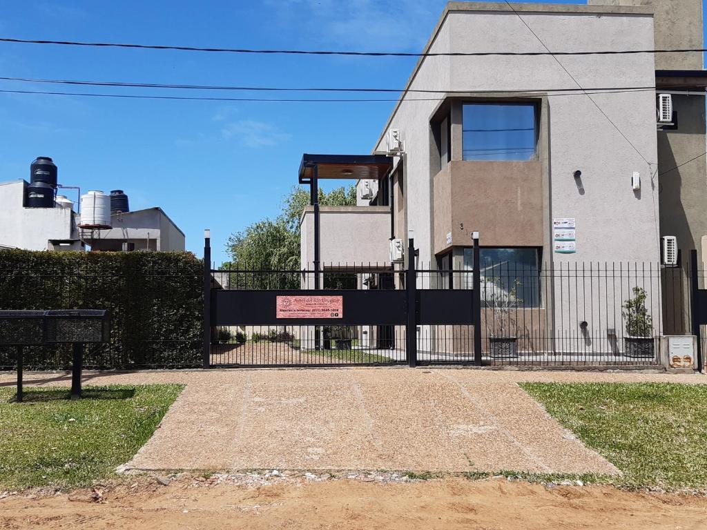 a gate with a sign in front of a building at Ayres Del Rio Uruguay in Colón