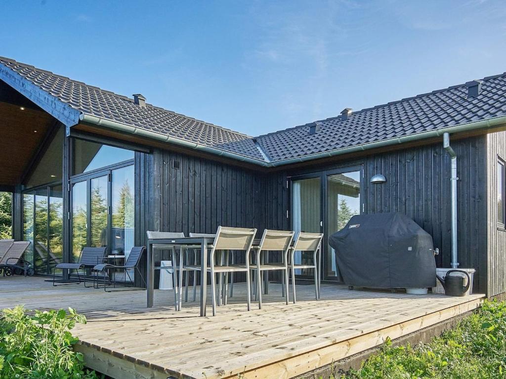 eine Terrasse mit Stühlen und einem Grill auf einem Haus in der Unterkunft Holiday home Aakirkeby XXI in Vester Sømarken