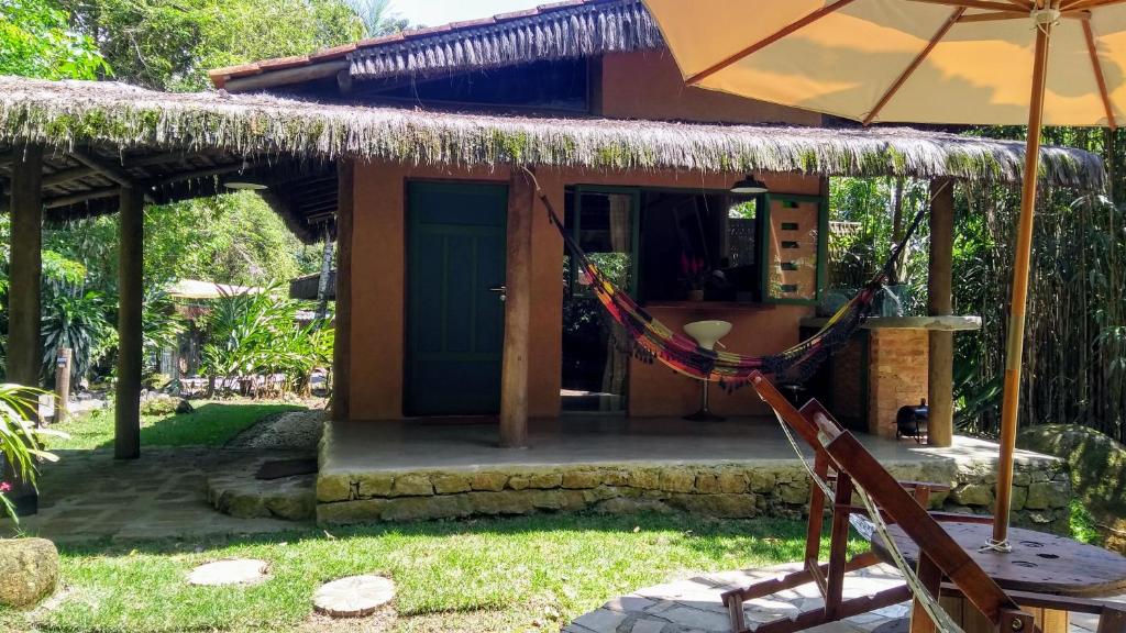 a house with a hammock in front of it at Cabana Rio in Ilhabela