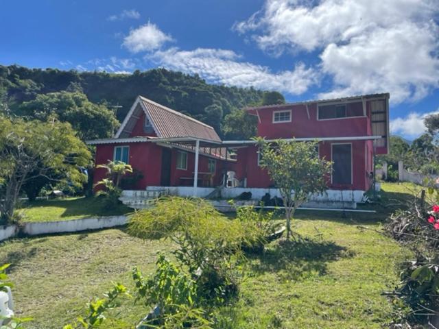 una casa roja con un gran patio delante en Cabañas Mountain View, en Volcán