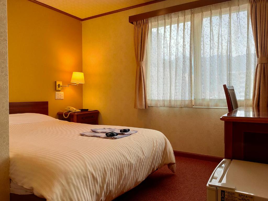 Un pat sau paturi într-o cameră la Beppu Station Hotel