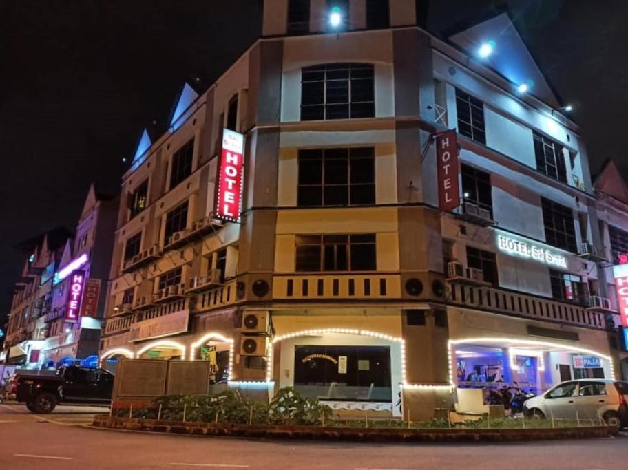 wysoki budynek z neonowymi znakami na boku w obiekcie HOTEL SRI SUTRA (BANDAR SUNWAY) w mieście Petaling Jaya