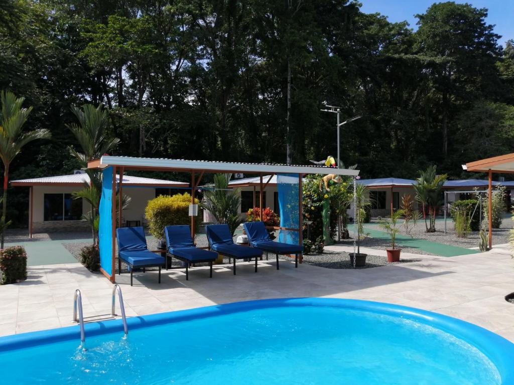 una piscina con sillas y un cenador en Puerto Vargas lodge, en Cahuita