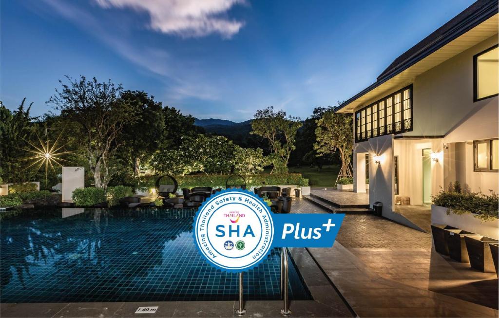 An illuminated outdoor swimming pool beside the villa, with landscaped grounds and mountain scenery.