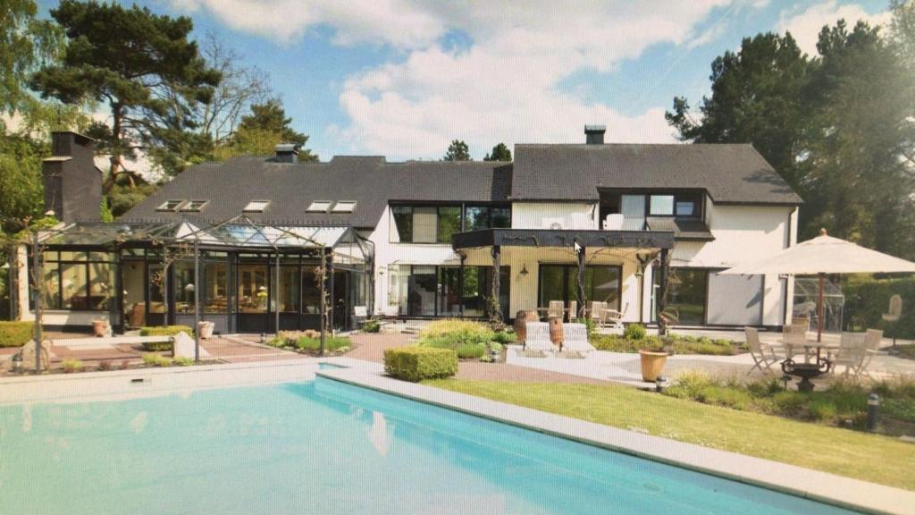 uma casa com uma piscina em frente em Meer aan het meer em Keerbergen