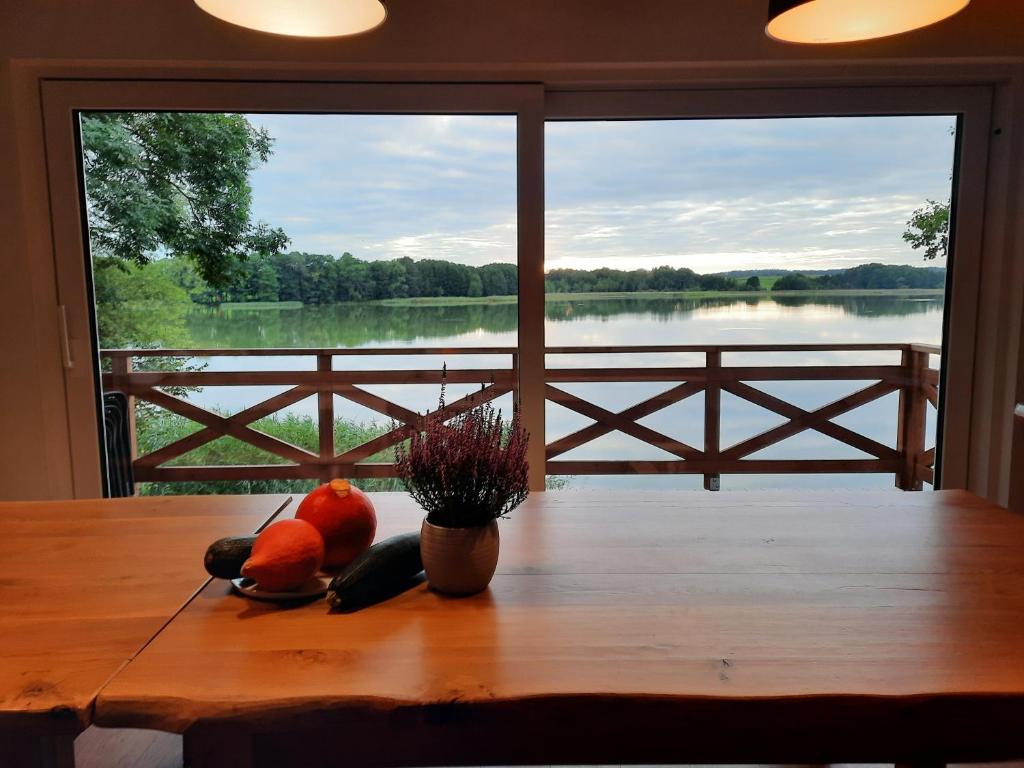 una mesa con fruta y vistas al lago en Mazurska Stodola, en Dłużec