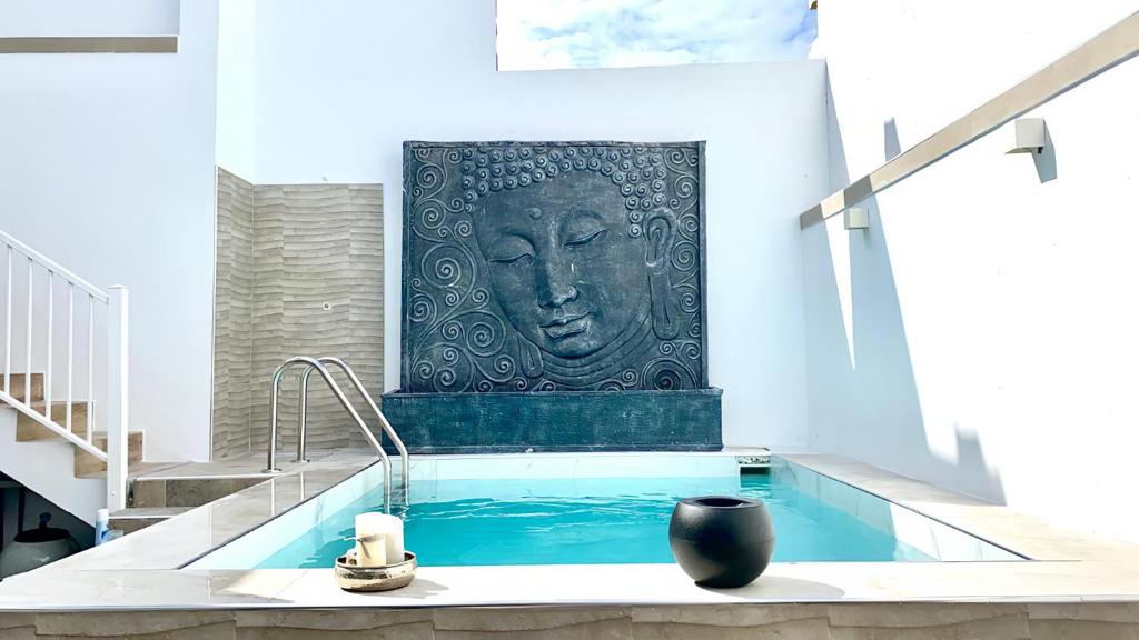 einen Pool mit einer Statue eines Kopfes an der Wand in der Unterkunft Villa Ocean View - Costa Adeje - Near Golf - Tenerife South - Canary Islands - Spain in Armeñime