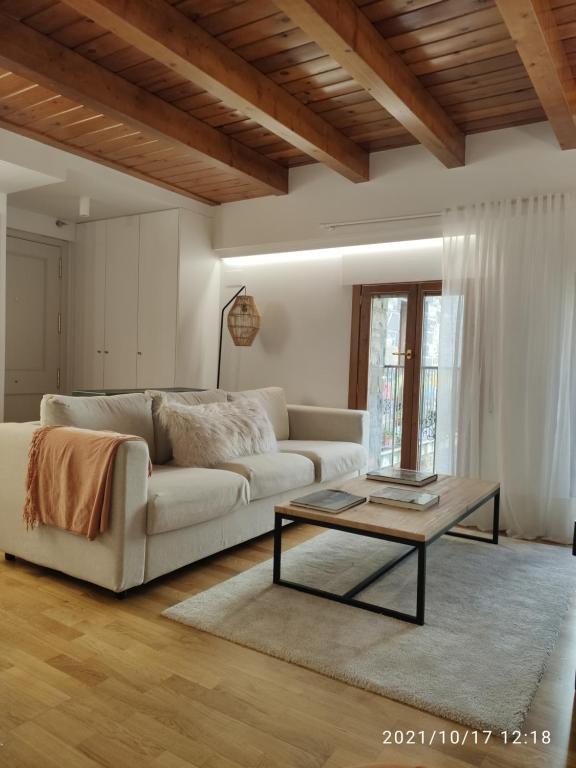 een woonkamer met een witte bank en een salontafel bij Bamboo I - tucasaenlospirineos in Escarrilla