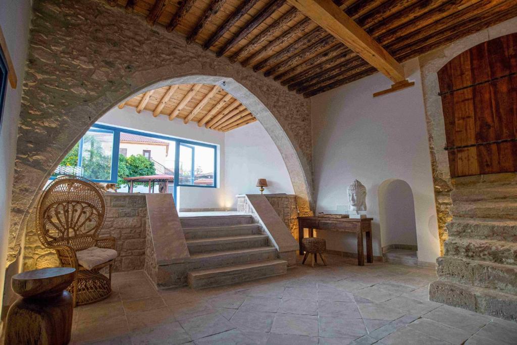 een kamer met een boog, een tafel en een trap bij The Courtyard Episkopi Guest Houses in Episkopi Lemesou