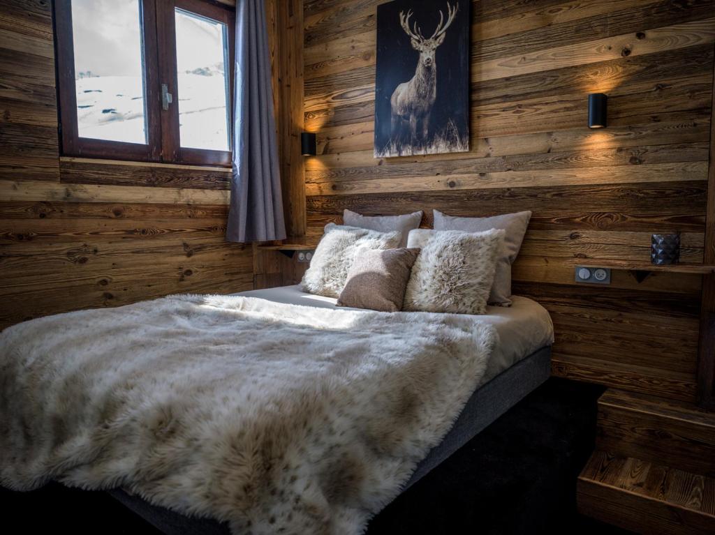 Schlafzimmer mit einem Bett mit Holzwänden und einem Fenster in der Unterkunft Magnifique Duplex Oneigedor Départ ski aux pieds et vue montagne in Tignes