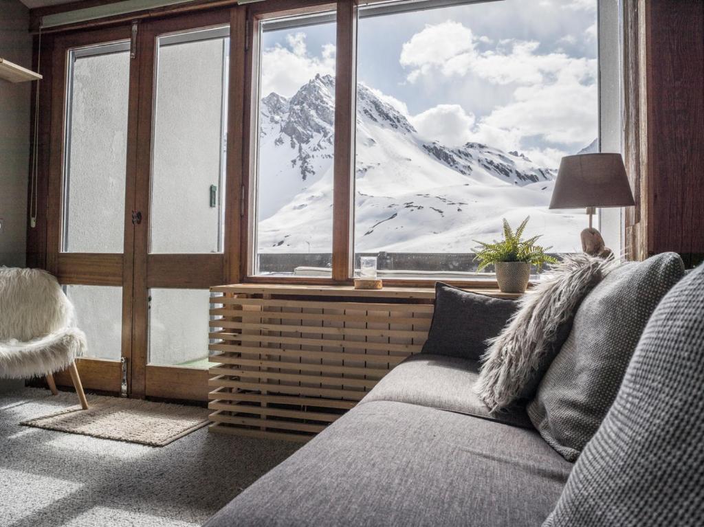 uma sala de estar com vista para uma montanha coberta de neve em Magnifique Duplex Oneigedor Départ ski aux pieds et vue montagne em Tignes