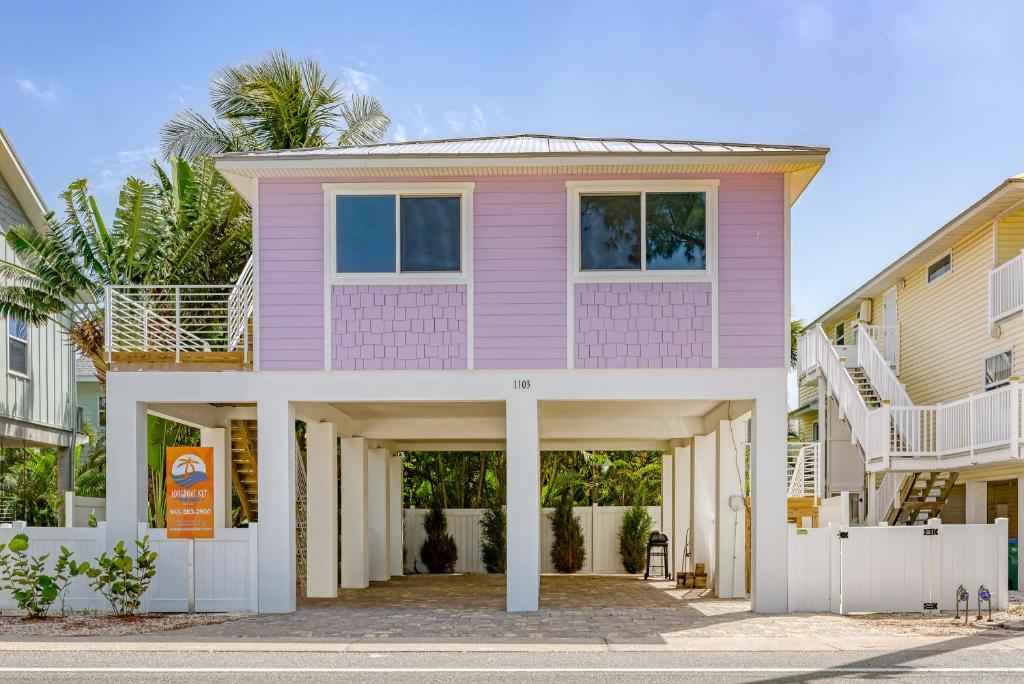 uma casa cor-de-rosa numa rua com edifícios em AMI Gulf Lookout-Views Of The Gulf From Every Room-Rooftop Terrace em Bradenton Beach