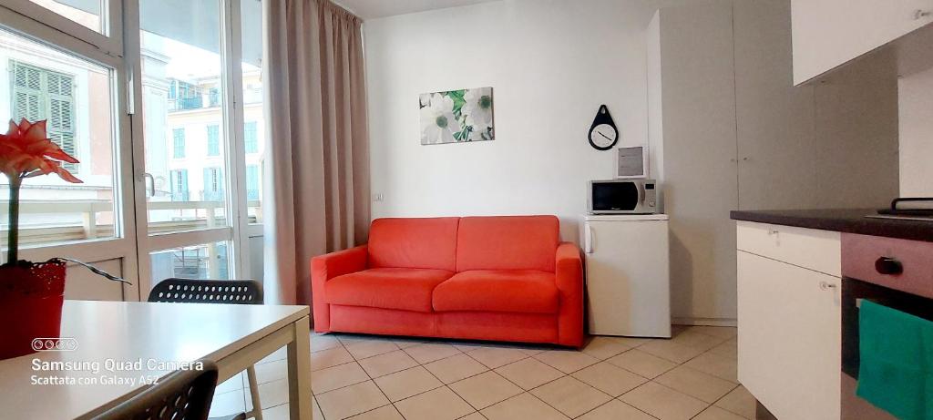 a living room with a red chair in a kitchen at Sanremo DOLCE DORMIRE in Sanremo