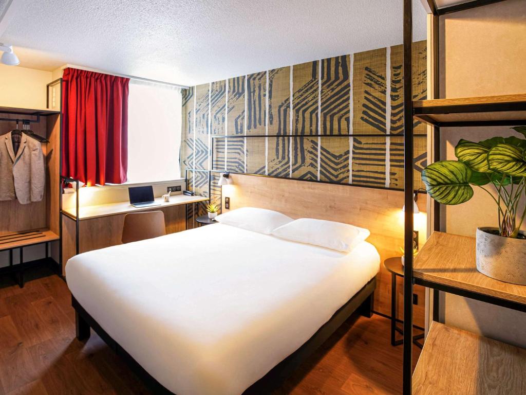 - une chambre avec un grand lit blanc dans l'établissement Ibis Tours Centre Giraudeau, à Tours