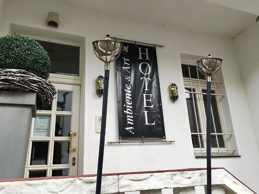 una señal negra en el frente de una casa en Hotel Ambiente et Art en Düsseldorf
