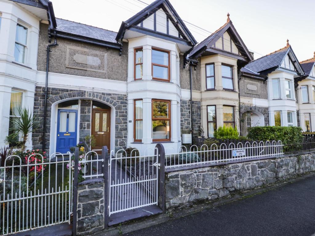 a row of houses with a white fence at Carlyn in Caernarfon