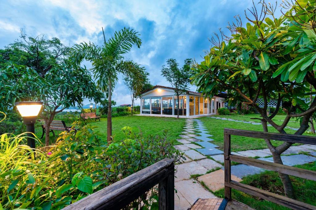 uma casa com um jardim e uma cerca em SaffronStays Le Soil, Igatpuri - pet-friendly villa with viewing deck for panoramic views em Igatpuri