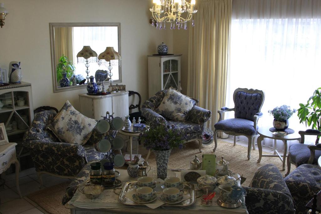 een woonkamer met banken en stoelen en een tafel bij A Summer Place Boutique Guest House in Bloemfontein