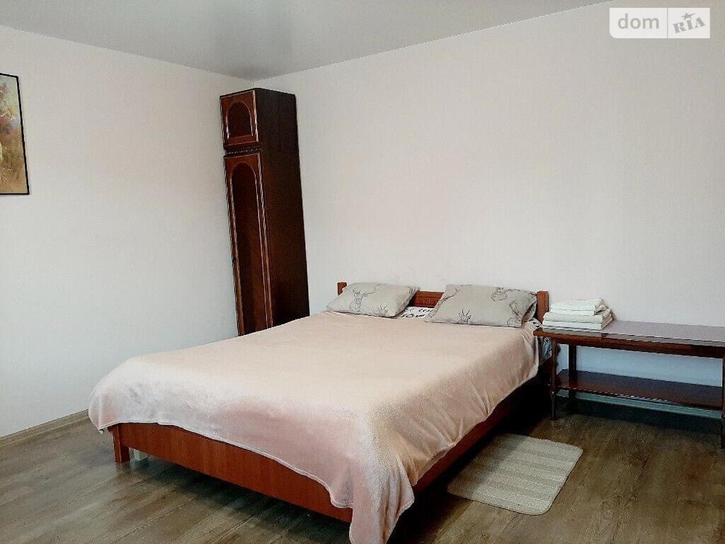 a bedroom with a bed with a wooden headboard and a table at Family and friends apartment in Ternopil