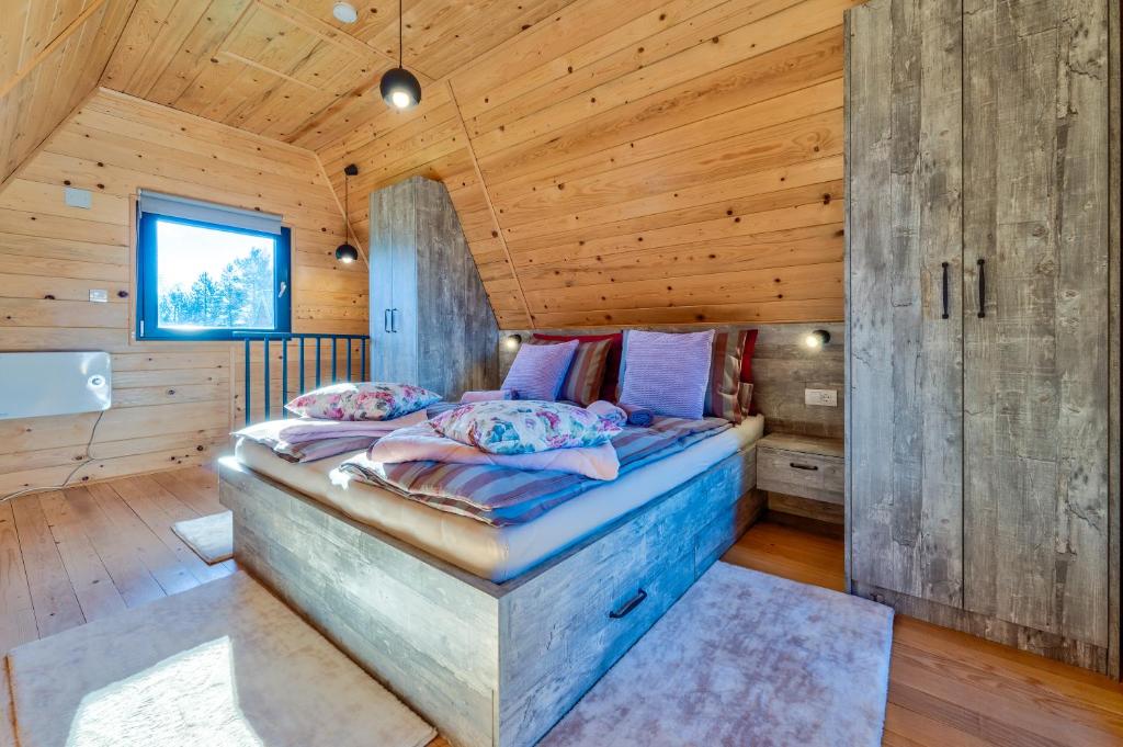 a bedroom with a bed in a wooden room at Brvnare Lovor in Krajevi