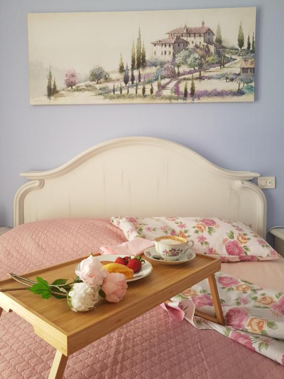 - une table avec un plateau de nourriture sur le lit dans l'établissement The Roses - Delizioso attico su 2 livelli zona Palacongressi, à Rimini