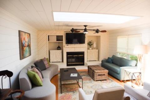 een woonkamer met een bank en een tv bij Beach Blossom - Bright, Updated Unit with Hot Tub on Patio in Hilton Head Island