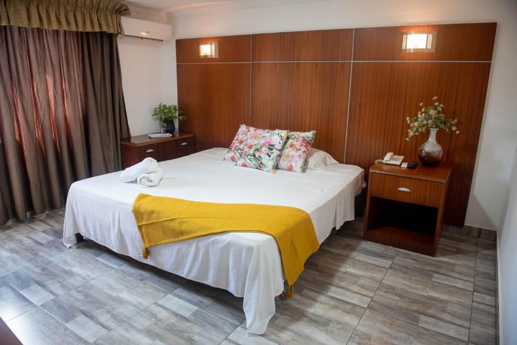 a hotel room with a bed with a yellow blanket on it at Cresta Inn in Panama City