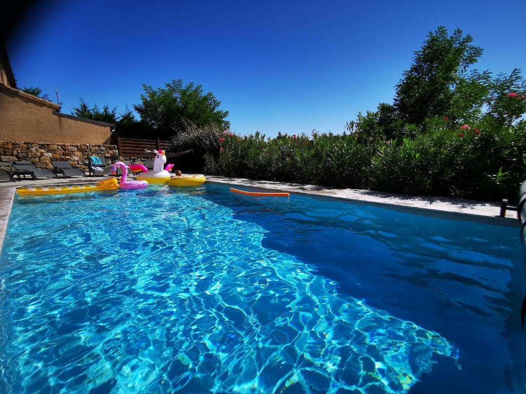 una piscina con agua azul en un patio trasero en Magnifique gite en pierres 6 personnes avec piscine privee Ardeche plein sud, en Lablachère