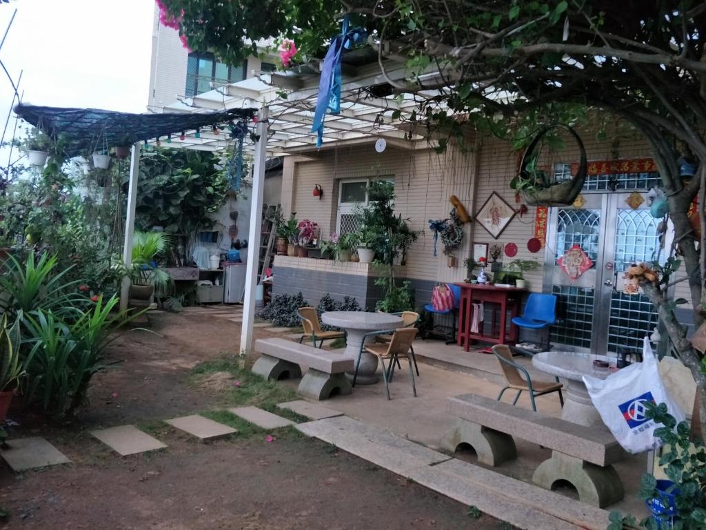 un patio con mesa y sillas y un edificio en 豪鵬遊民宿2館, en Jincheng