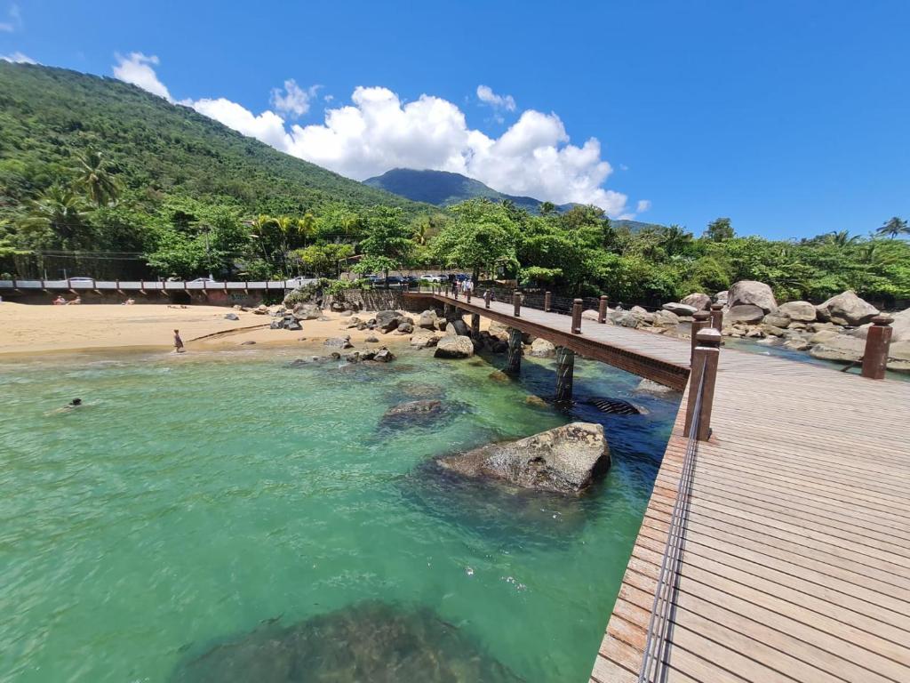 a bridge over the water on a beach at Pousada Por do Sol in Ilhabela