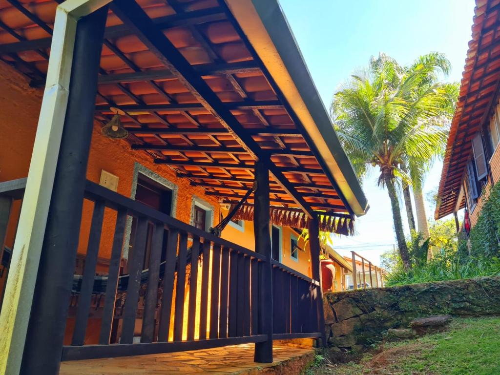 an orange building with a gate and palm trees at Pousada Por do Sol in Ilhabela