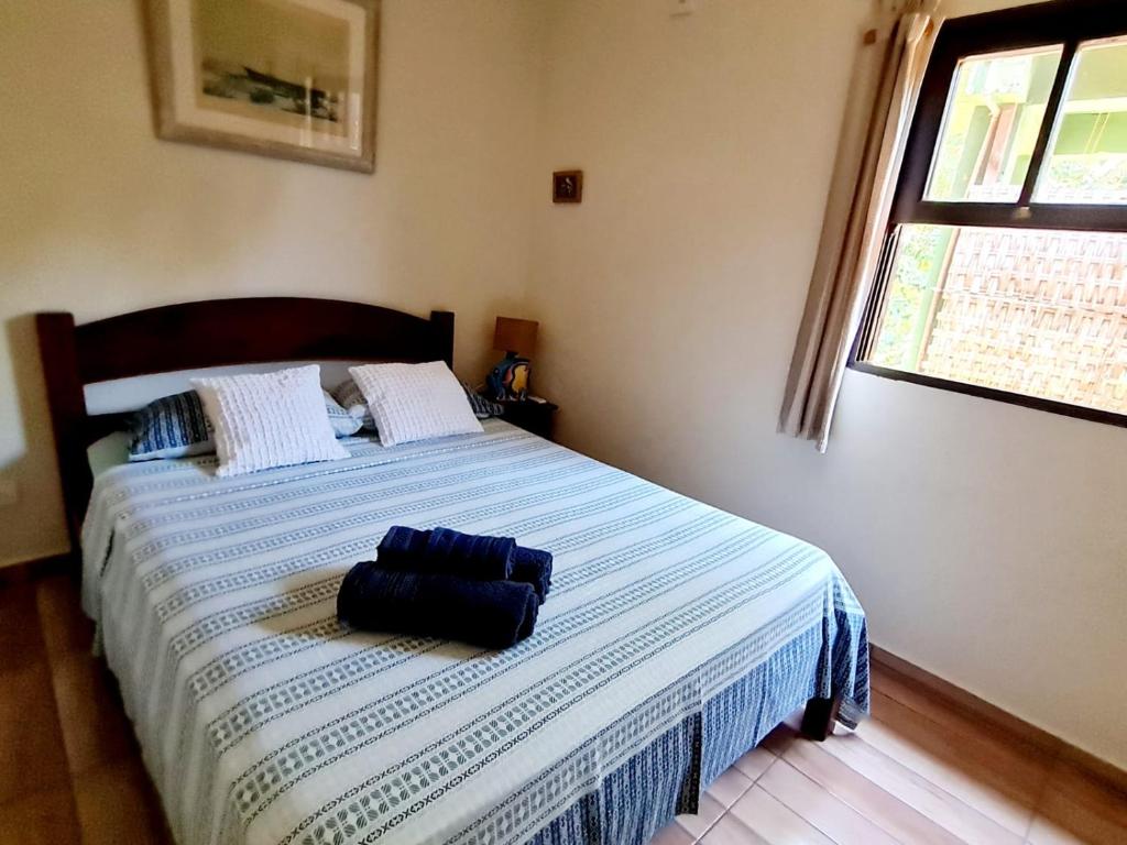 a blue bag sitting on a bed in a bedroom at Pousada Por do Sol in Ilhabela