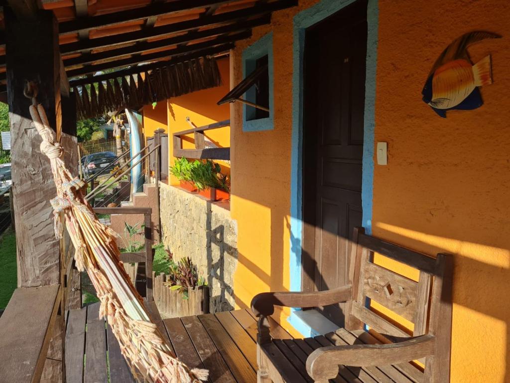 a porch of a house with a hammock and a door at Pousada Por do Sol in Ilhabela