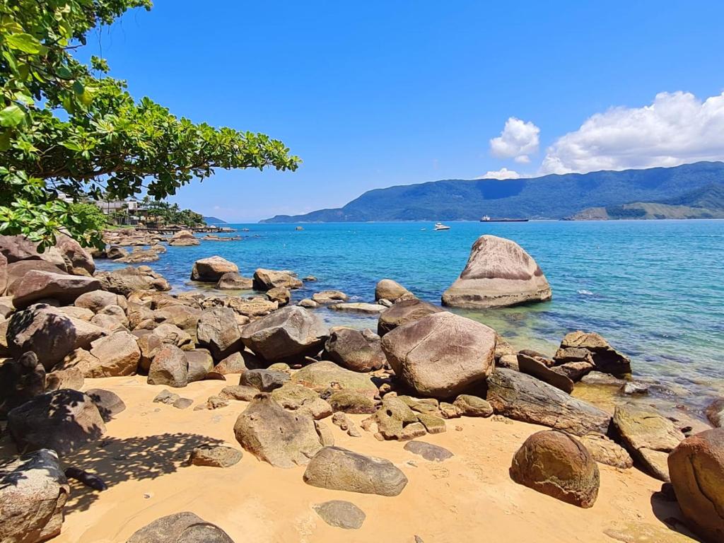 a group of rocks on a beach near the water at Pousada Por do Sol in Ilhabela