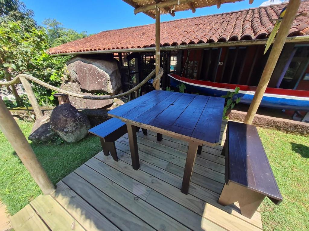 a blue picnic table on a deck in front of a house at Pousada Por do Sol in Ilhabela