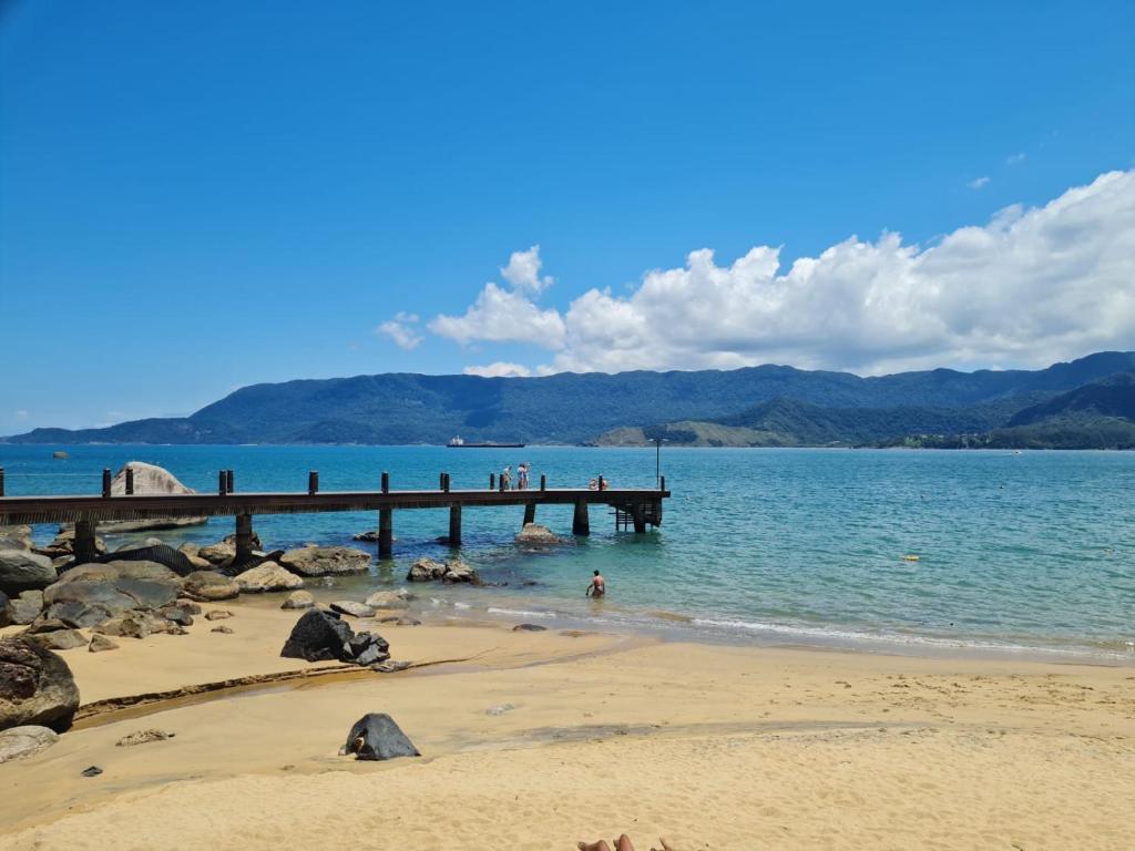 a group of people standing on a pier on the beach at Pousada Por do Sol in Ilhabela