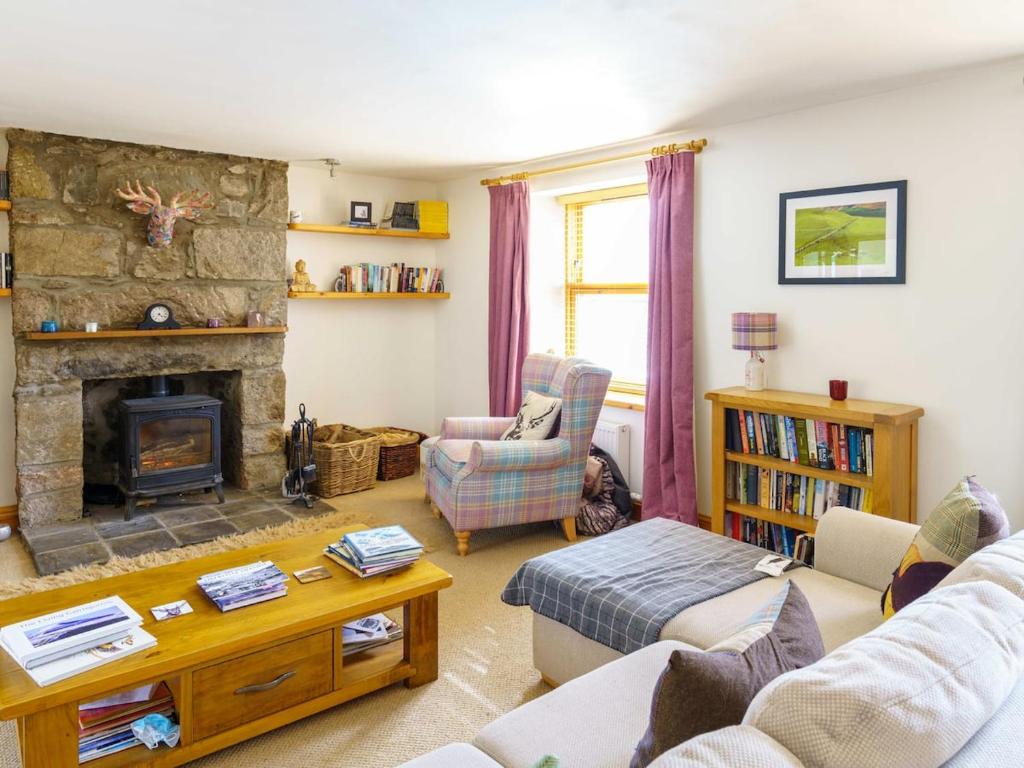 a living room with a couch and a fireplace at Milne's Brae, cosy, comfortable and centrally located in beautiful Braemar in Braemar