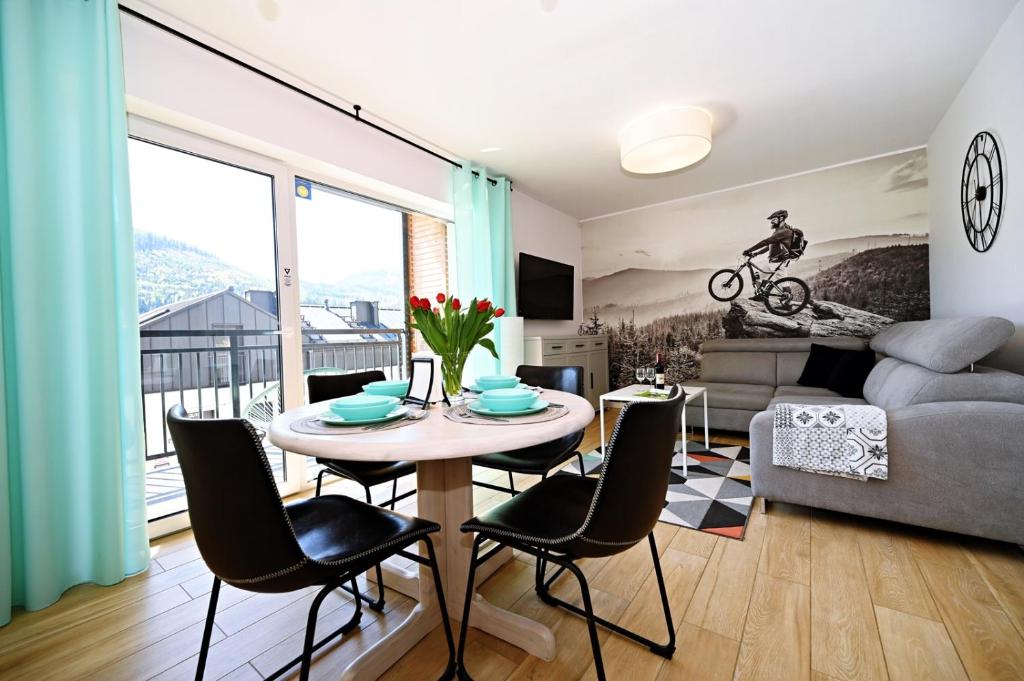 a living room with a table and chairs at Szczyrk Apartament Miętowy - Słoneczna Góra in Szczyrk