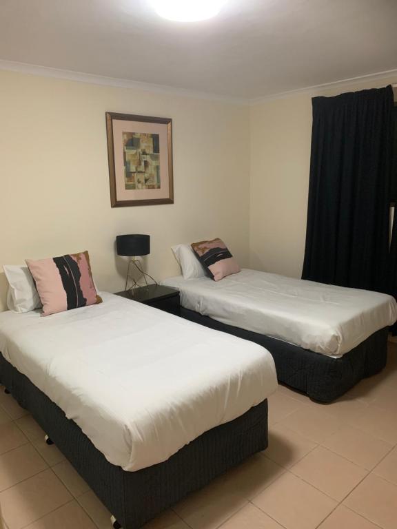 Dos camas en una habitación de hotel con faldas. en SA house, en Modbury