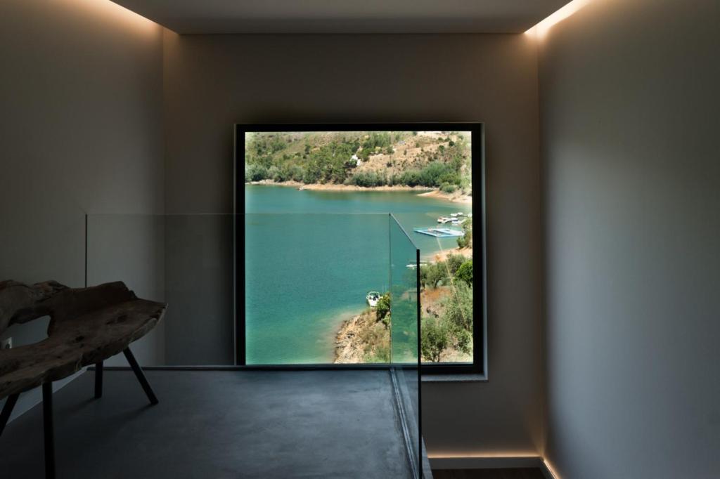 Habitación con vistas al lago a través de una ventana. en Zab Living, en Vila de Rei