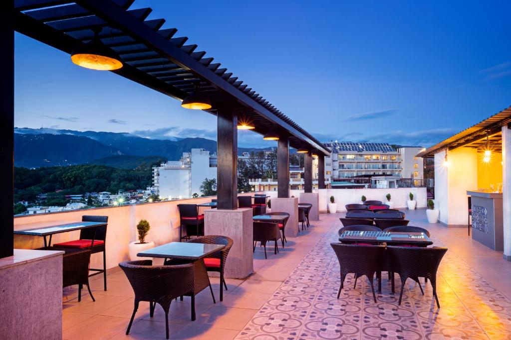 a restaurant with tables and chairs on a balcony at Spree Hotel Kriday Dehradun in Dehradun