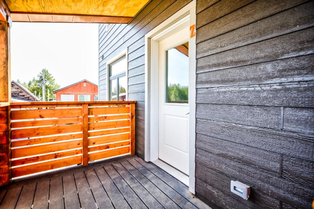 a porch with a white door and a wooden wall at Castle in the Sky Unit Z in West Yellowstone