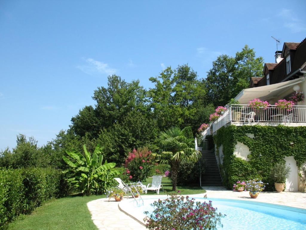 un jardin avec une piscine et une maison dans l'établissement Villa Ric, à Saint-Céré