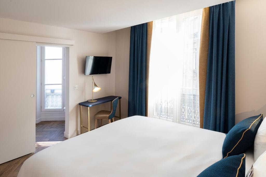 Uma cama ou camas num quarto em Mercure Paris Opera Lafayette