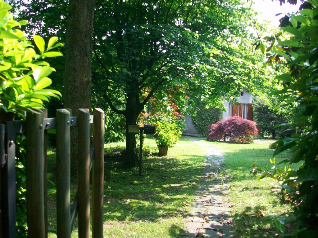 a wooden fence in a yard with trees and grass at B&B L'Albero Maestro in Orsenigo