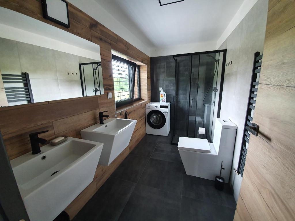 La salle de bains est pourvue de 2 lavabos, de toilettes et d'une douche. dans l'établissement Relax Vila Lipno 2 u pláže Windy Point, à Černá v Pošumaví