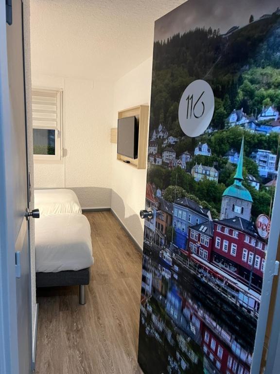 ein Schlafzimmer mit einer Tür mit einem Bild einer Stadt in der Unterkunft Kyriad Direct Reims Bezannes in Reims