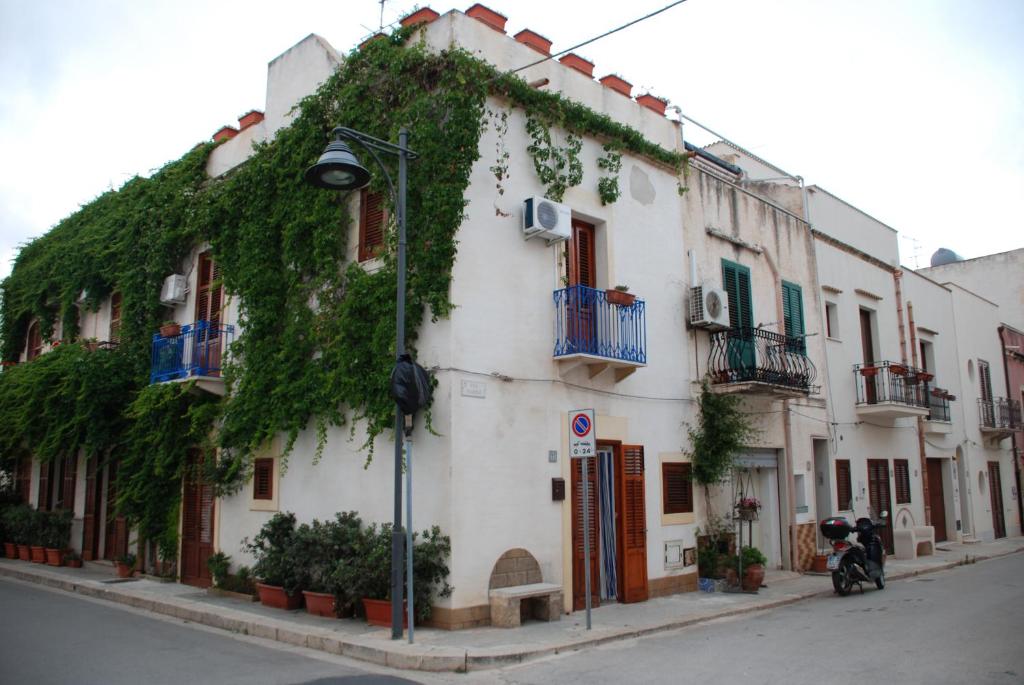 a building with ivy growing on the side of it at Casa Cipolla in San Vito lo Capo